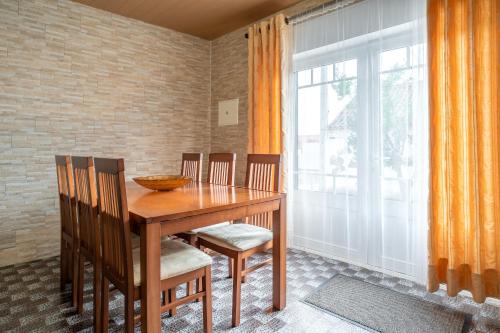 a dining room with a wooden table and chairs at Murta's Home in Cadaval