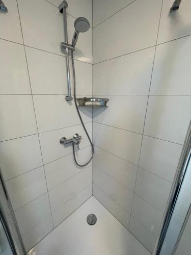 a shower in a bathroom with white tiles at Moderne Wohnung nah am Cappenberger-See, 1-4 Gäste in Lünen
