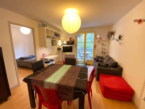 un salon avec une table à manger et un salon dans l'établissement T2 alcove confortable pour 4 à 5p. Balcon. Parking, à Cauterets