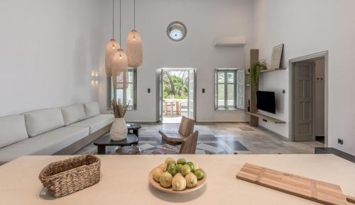 Sunset Mansion في بلاكا ميلو: غرفة معيشة مع أريكة وطاولة مع وعاء من الفاكهة