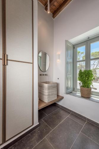 a bathroom with a sink and a window at Sunset Mansion in Plaka Milou