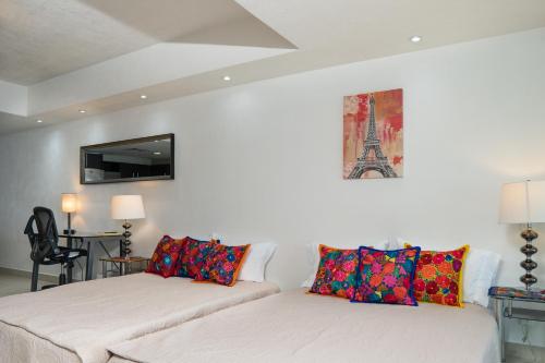 two beds in a room with a couch and a tv at Ocean Front Condo Sleeps 4 Adults-Grand Venetian T3000-1606 in Puerto Vallarta