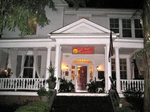 una casa blanca con un cartel en la puerta principal en Inn Upon Moon River Plantation, en Chester