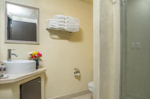 a bathroom with a sink and a toilet and a mirror at Ocean Front Condo Sleeps 4 Adults-Grand Venetian T3000-1606 in Puerto Vallarta