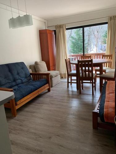 a living room with a couch and a table at DEPARTAMENTOS TERMAS DE CHILLAN in Nevados de Chillan