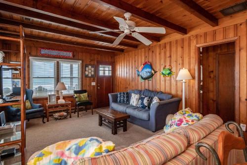 a living room with a couch and a ceiling fan at Lowe Tide by Oak Island Accommodations in Oak Island