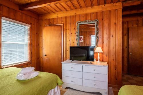 a bedroom with a tv on top of a dresser at Lowe Tide by Oak Island Accommodations in Oak Island