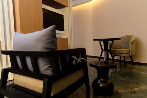 a room with a chair with a pillow and a table at Best Western Plus Soaho Douala Airport in Douala