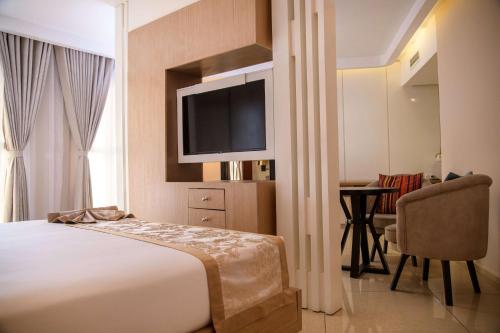 a hotel room with a bed and a television at Best Western Plus Soaho Douala Airport in Douala