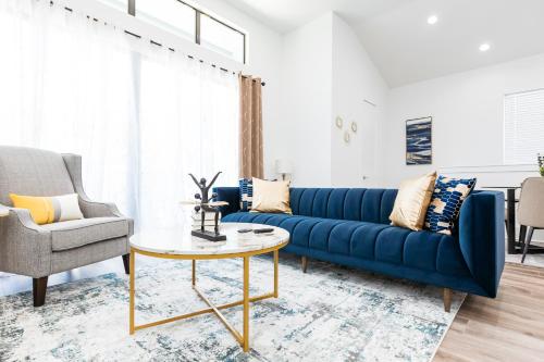 Downtown Houston Modern Home في هيوستن: غرفة معيشة مع أريكة زرقاء وطاولة