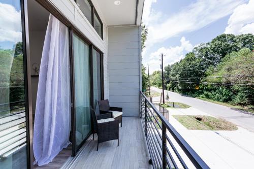 einen Balkon mit einem Stuhl und Straßenblick in der Unterkunft Downtown Houston Modern Home in Houston