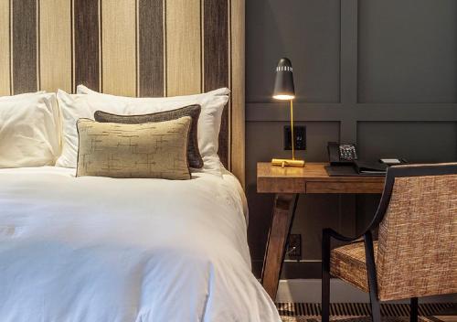 a bedroom with a bed and a desk with a lamp at Ojai Valley Inn in Ojai