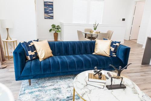 a blue couch in a living room with a table at Beautifully Decorated, Modern Downtown Houston Home in Houston