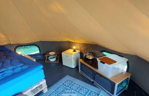 a tent with a bed and a table in it at Charmecamping & Appartementen De Regge-Vallei in Den Ham