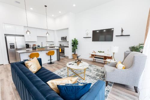 a living room with a blue couch and a kitchen at Beautifully Decorated, Modern Downtown Houston Home in Houston