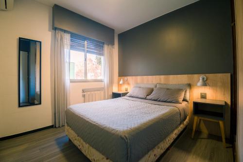Un dormitorio con una cama grande y una ventana en Chill Inn Hostel en Mendoza