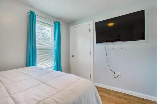 a bedroom with a bed and a flat screen tv on the wall at Downtown Brockton Apt Less Than 1 Mi to Local Dining in Brockton