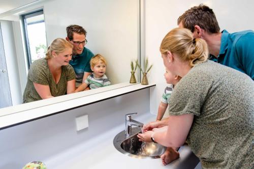 a group of people standing around a bathroom sink at Charmecamping & Appartementen De Regge-Vallei in Den Ham