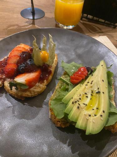 two slices of bread with fruit and vegetables on a plate at Dim's Hotel & Restaurant in Korçë