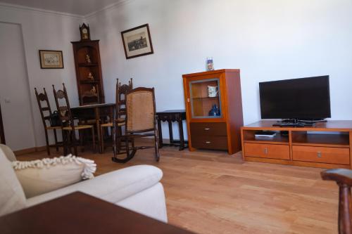 a living room with a couch and a flat screen tv at Gustavo's Place in Sines