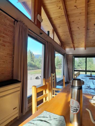 a dining room with a table and a large window at PUERTO HOSTEL in El Hoyo