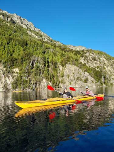 two people in a yellow kayak on a lake at PUERTO HOSTEL in El Hoyo