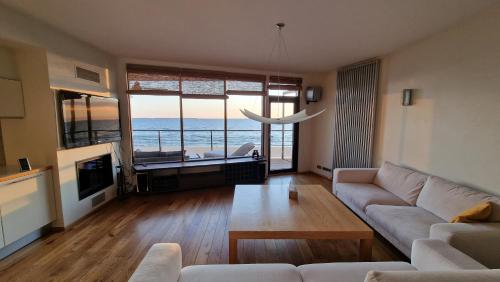 a living room with a couch and a view of the ocean at Pirita Beach View Suites in Tallinn