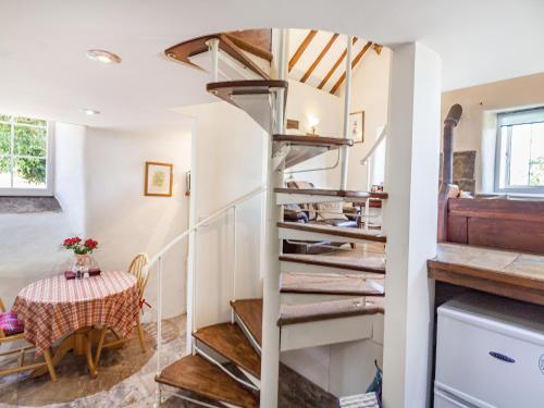 a home with a spiral staircase and a table at The Old Chapel in Matlock
