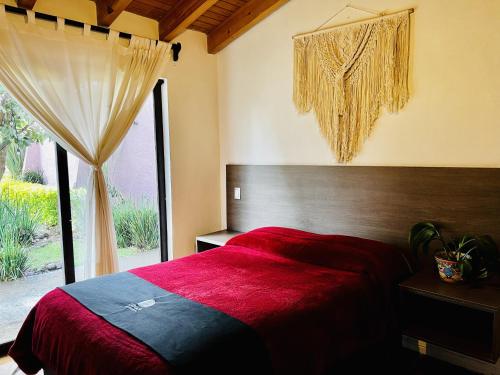 una camera con letto rosso e finestra di Casa Lunah Avandaro a Valle de Bravo