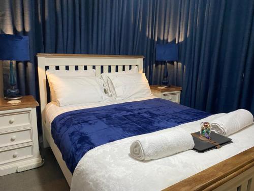 a bedroom with a large bed with blue curtains at Freshwater BnB in Hervey Bay