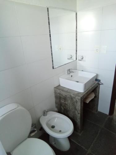 Un baño con un inodoro blanco y un lavabo. en Luna Gris, en La Pedrera