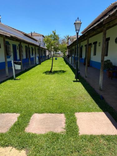 a grassy alley between two buildings with a street light at Pequeño Rocío Urbanizacion privada in El Rocío