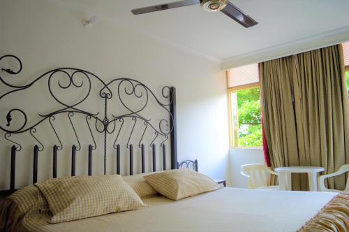 1 dormitorio con 1 cama con cabecero blanco y negro en Hotel Terraza, en Girardot