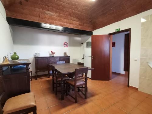 a kitchen and dining room with a table and chairs at Casa do Castelo in Arraiolos
