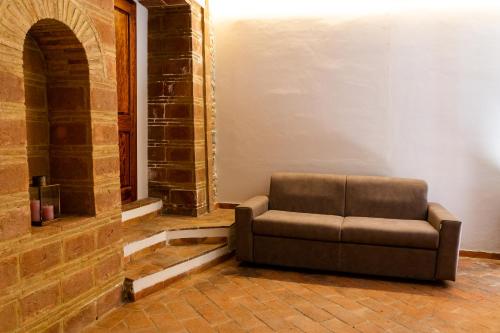 a brown couch sitting in the corner of a room at Podere Mezzastrada - Place of Charme in Fiano