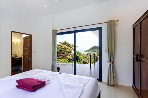 a bedroom with a bed and a view of the ocean at 2 Bays Villa in Thong Nai Pan Yai