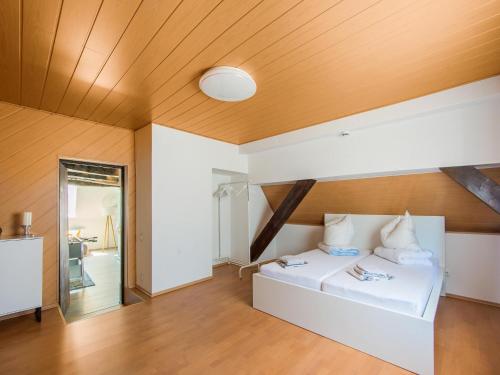 a bedroom with a white bed with a wooden ceiling at Ferienwohnung in Herbolzheim in Herbolzheim