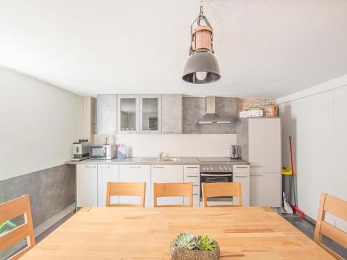 a kitchen with white cabinets and a table and chairs at Ferienwohnung in Herbolzheim in Herbolzheim