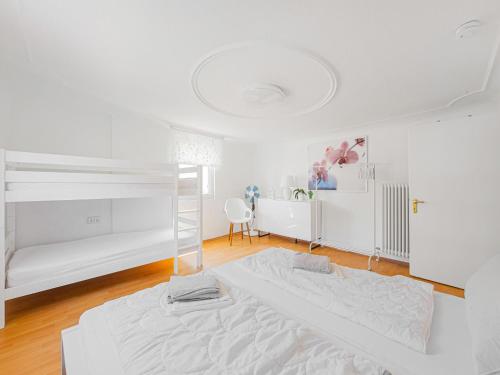 a white bedroom with a bed and a desk at Ferienwohnung in Herbolzheim in Herbolzheim