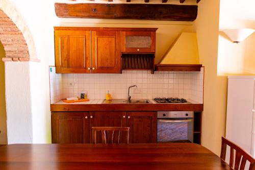 a kitchen with wooden cabinets and a sink at Podere Mezzastrada - Place of Charme in Fiano