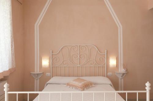 1 cama blanca con cabecero blanco en un dormitorio en Crealto, en Alfiano Natta