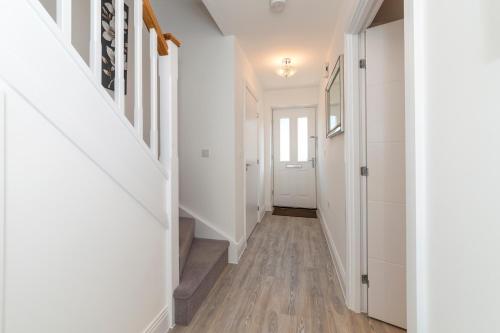 a hallway of a home with white walls and wood floors at Greenfield Holiday Homes in Bracknell