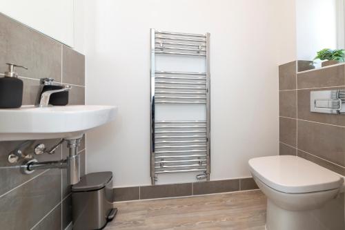 a bathroom with a toilet and a sink at Greenfield Holiday Homes in Bracknell