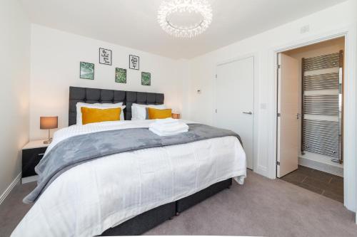 a bedroom with a large white bed with orange pillows at Greenfield Holiday Homes in Bracknell