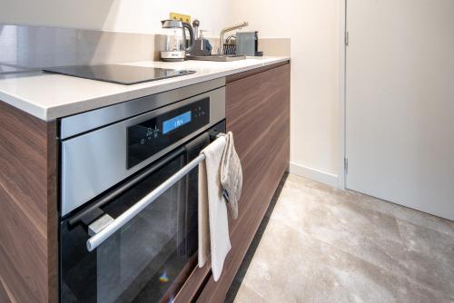 a kitchen with an oven and a sink at Family penthouse 7-Minutes from Rotterdam Central Newly Build top floor terrace R5 in Schiedam