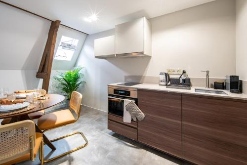 a kitchen with a table and a counter top at Family penthouse 7-Minutes from Rotterdam Central Newly Build top floor terrace R5 in Schiedam