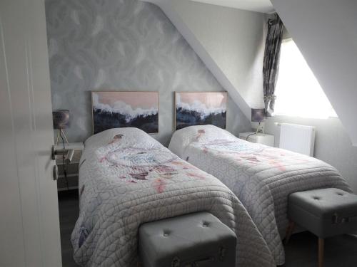 Un dormitorio con dos camas individuales y una ventana. en Chalet near Cap Frehel with Coastal Views, en Fréhel