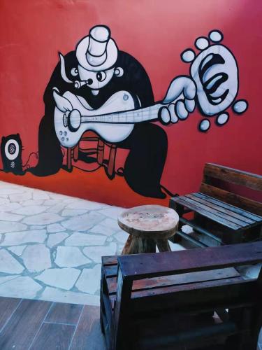 a wall with a painting of a cat playing a guitar at Pousada Blues in Ipiabas