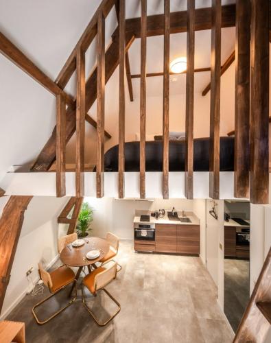 a loft kitchen with wooden beams and a table and chairs at Family penthouse 7-Minutes from Rotterdam Central Newly Build top floor terrace R5 in Schiedam