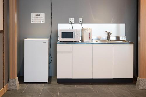 a kitchen with a microwave and a refrigerator at NINJA & GEISHA in Osaka